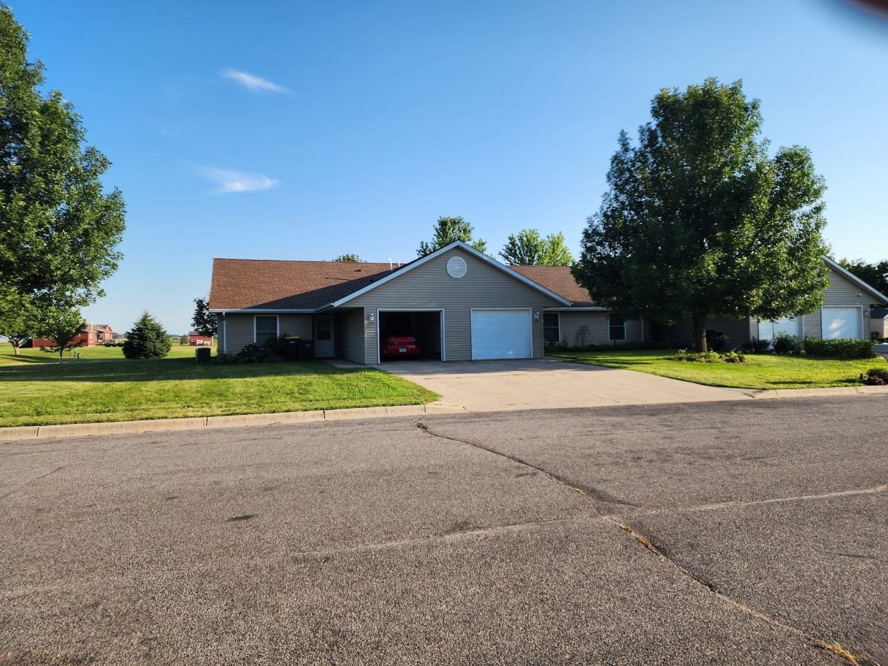 A single-story ranch home with a cared-for front lawn and driveway on a sunny day.
